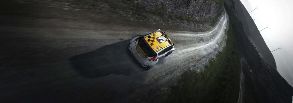 Yellow rally car racing on winding dirt road with dust and wind turbines under cloudy sky Wallpaper