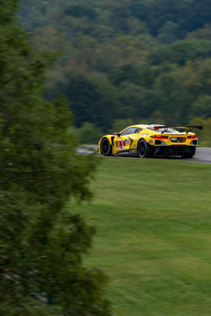 Sleek Yellow Sports Car on Winding Road: Speed & Precision Wallpaper