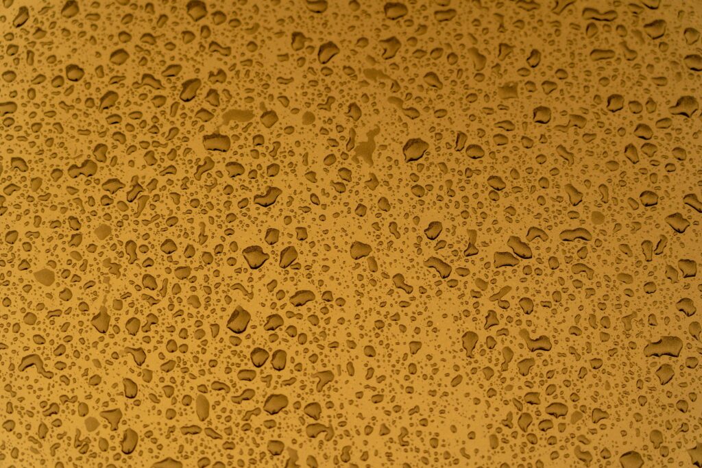 Dynamic Yellow Textured Wallpaper with Liquid Droplets - Macro Close-Up
