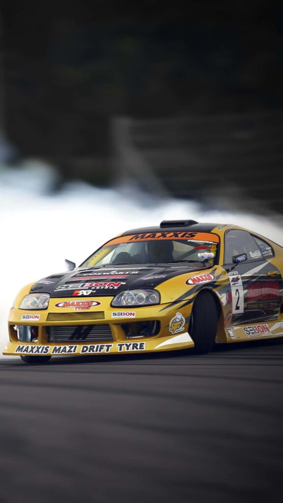 Yellow Toyota Supra drifting on racetrack with sporty modifications dynamic car wallpaper background