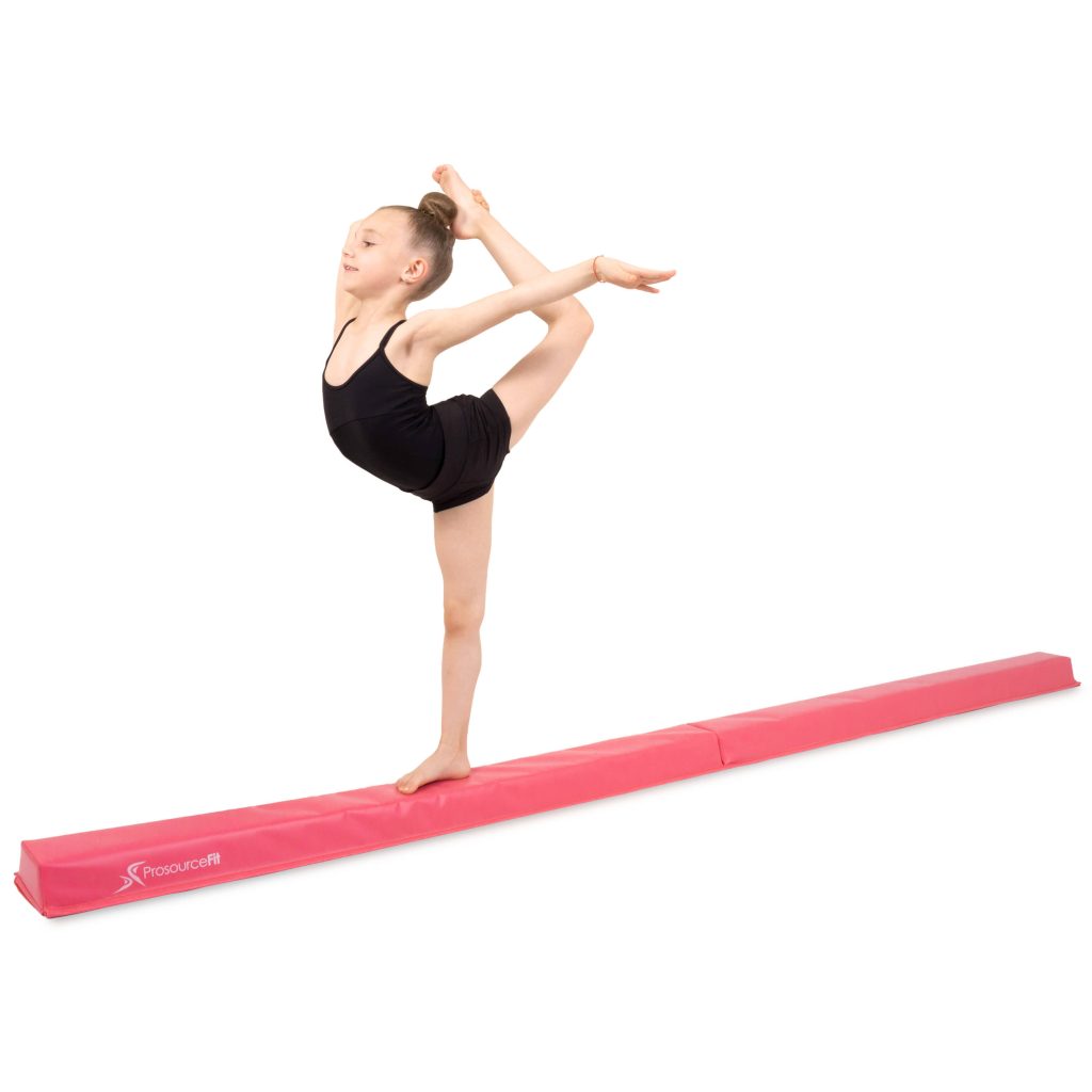Young gymnast balances gracefully on pink ProsourceFit floor beam in white studio background Wallpaper