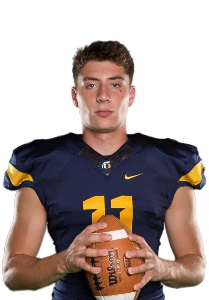 Young quarterback number 11 in navy gold jersey holding football intense professional wallpaper