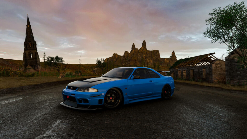 Beauty in Motion: Serene Blue Jdm Car Amidst Rocky Landscapes Wallpaper