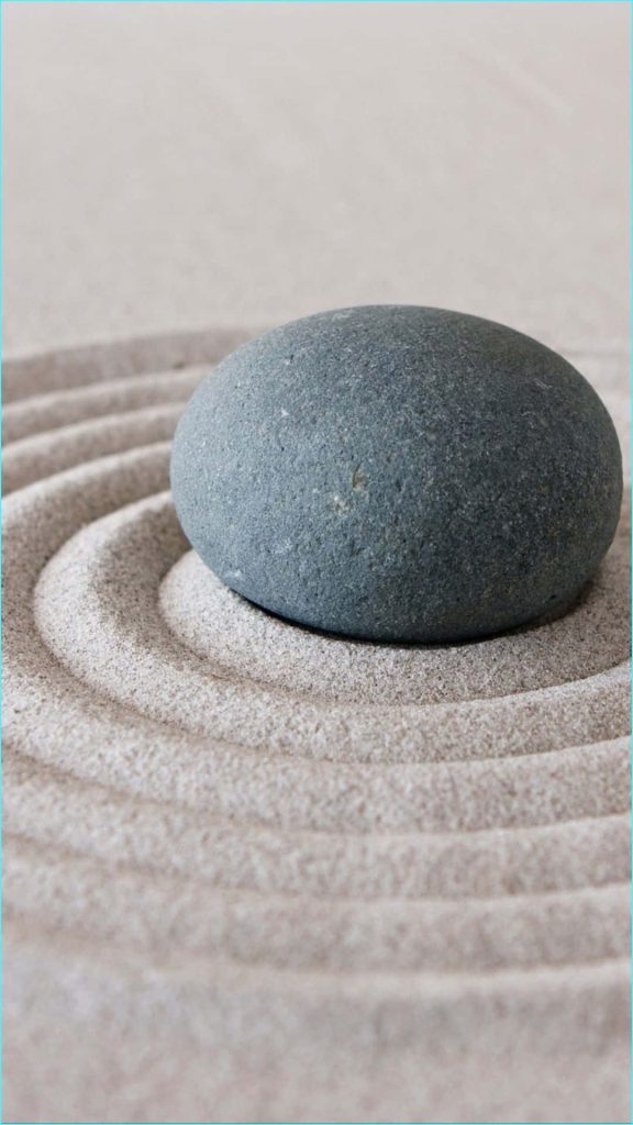 Zen garden wallpaper with dark stone on raked beige sand minimalist calming background for iPhone