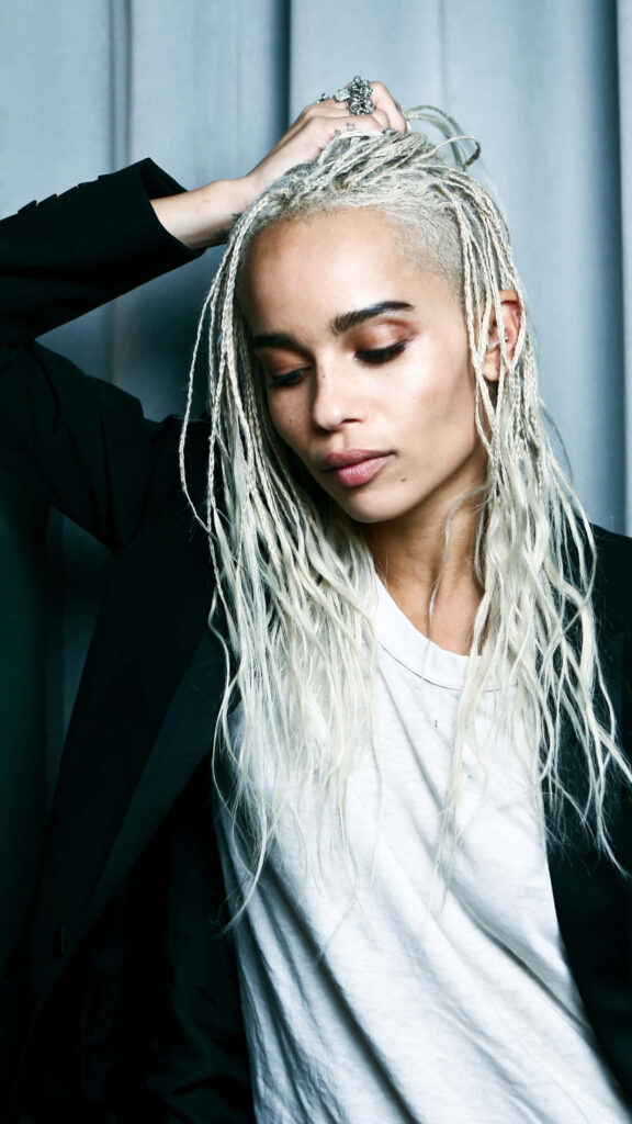 Zoë Kravitz platinum blonde braids contemplative pose stylish portrait simple wallpaper background