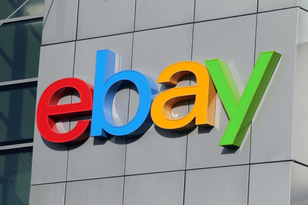 eBay logo in vibrant colors on gray modern building facade playful colorful brand wallpaper background